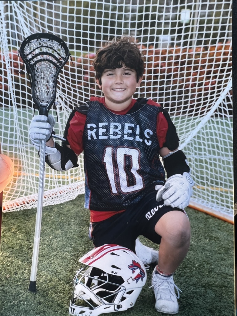 Brighton smiling in his lacrosse uniform